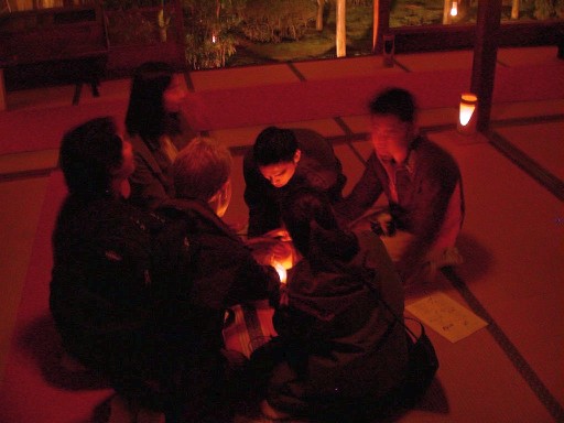 students huddled for warmth around charcoal